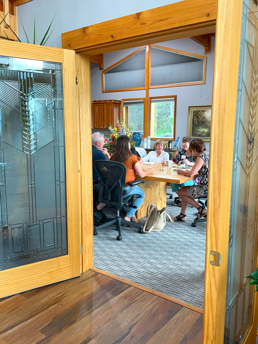 Glass doors opening into a room with people around a table