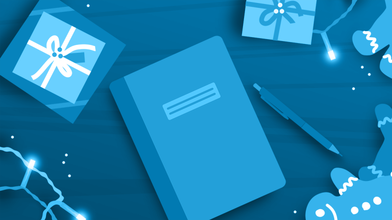 A journal and pen surrounded by gifts, string lights, and cookies